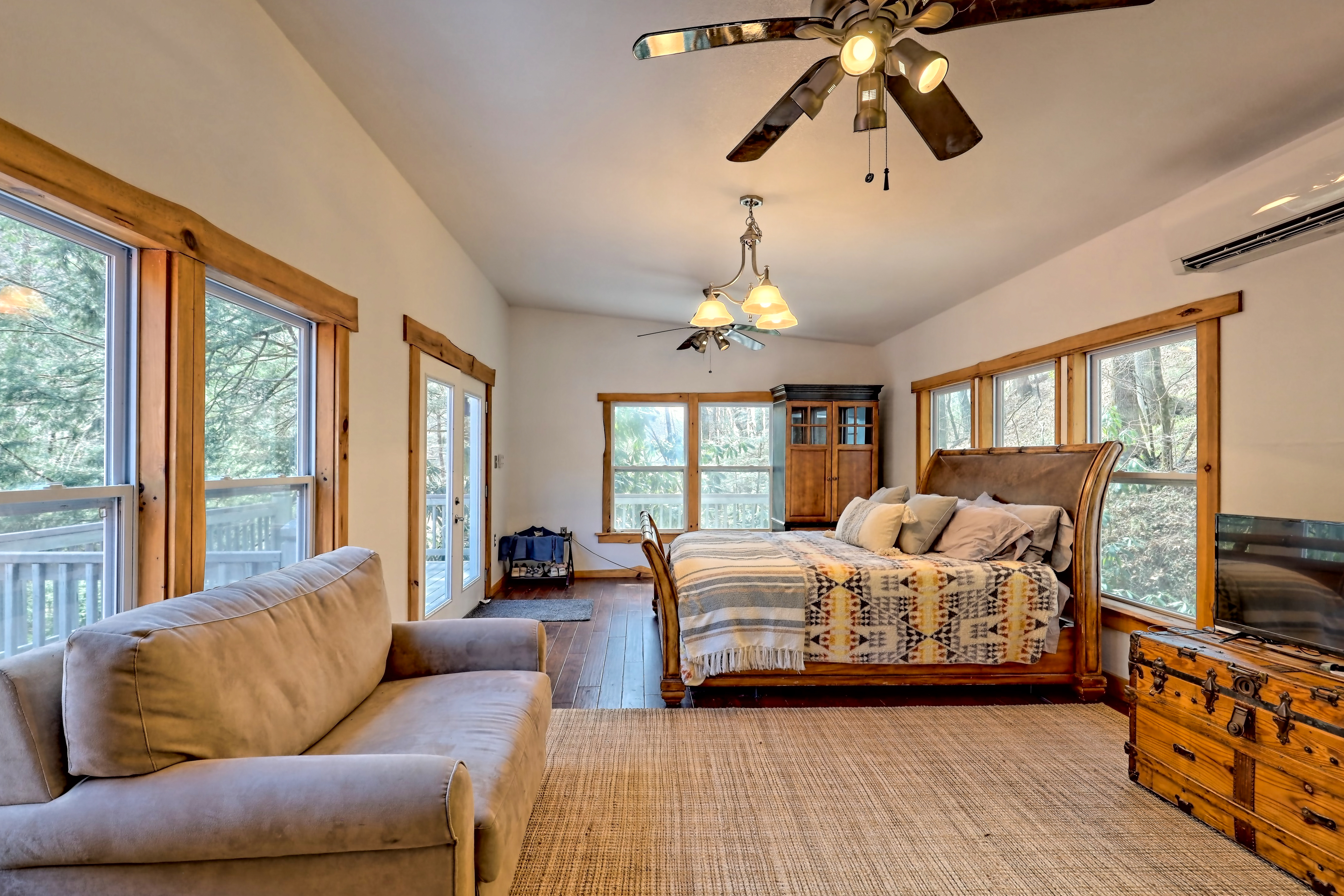 Bright bedroom with sitting area and forest views