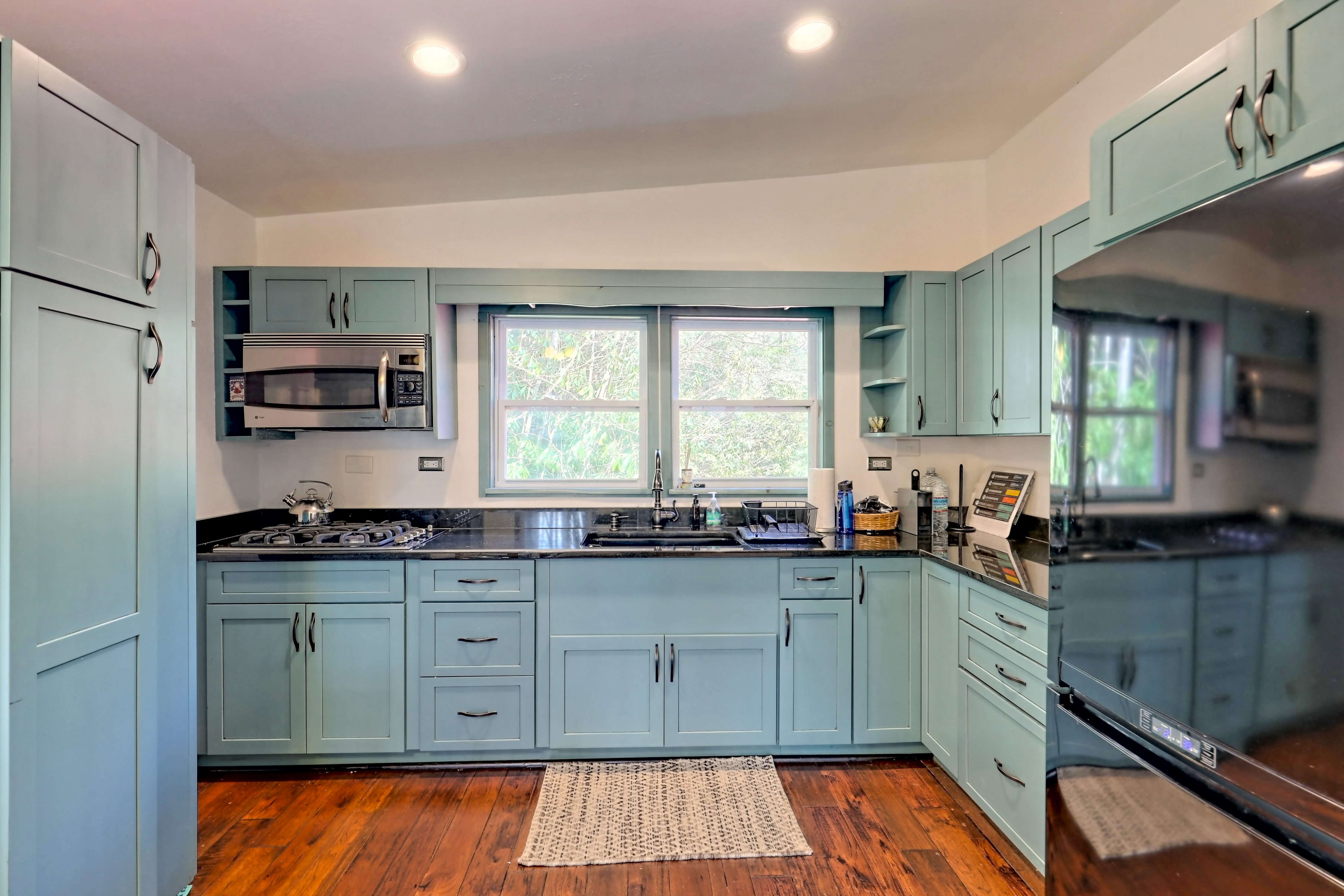 Light blue apartment kitchen with forest view