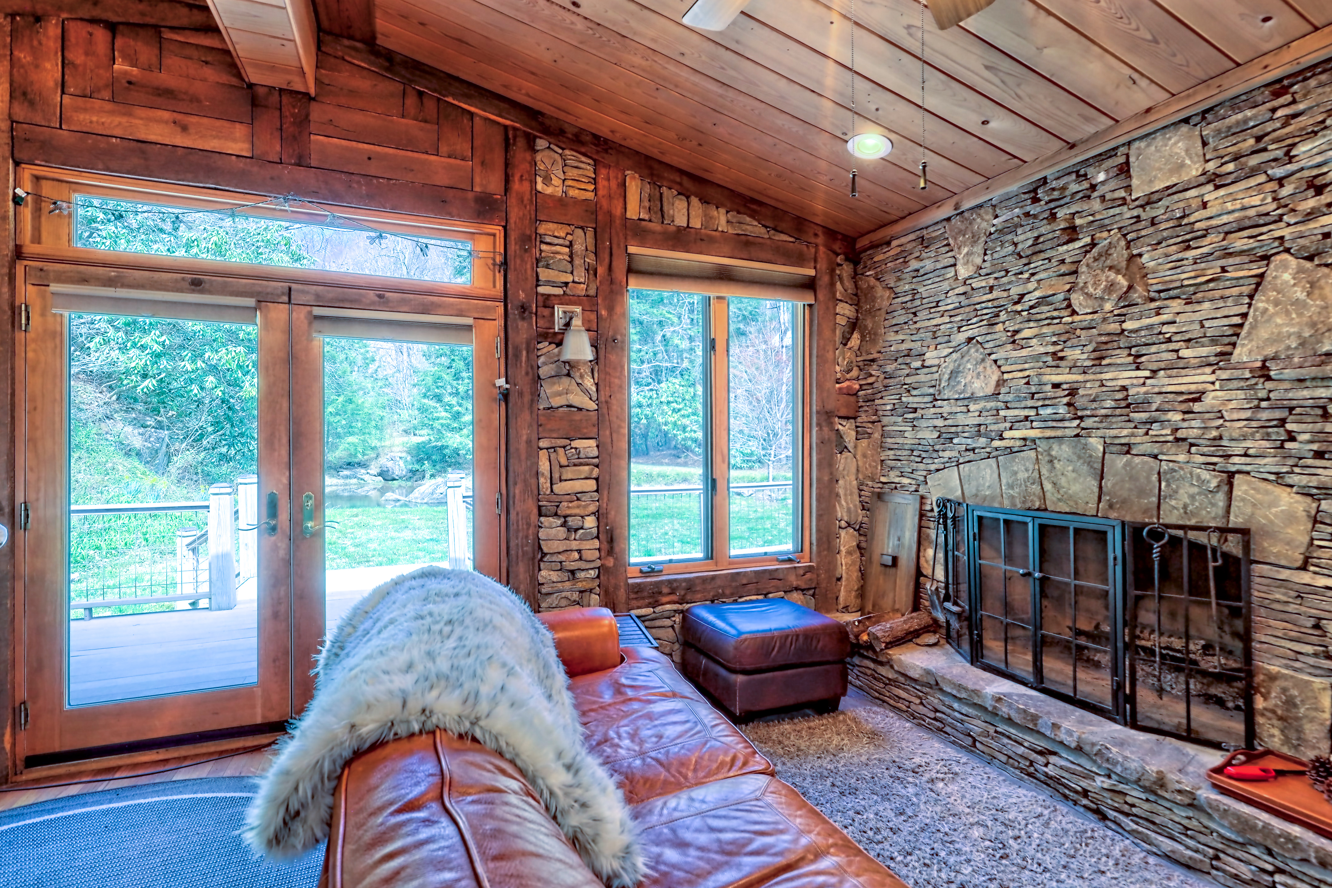 Rustic living room with stone fireplace and view to the river